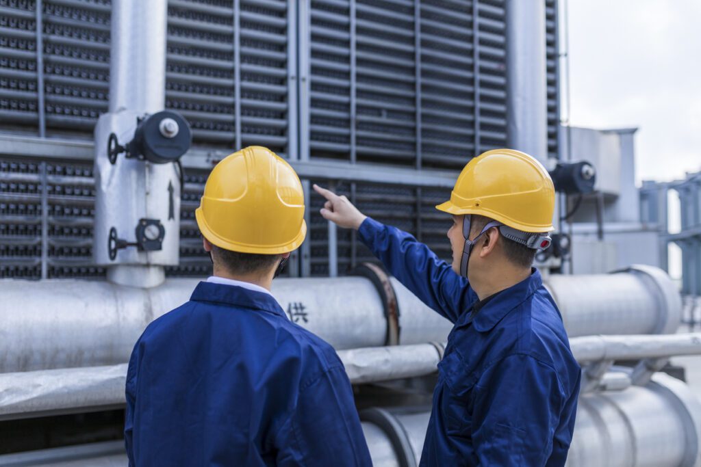 Two engineer colleagues examining cooling tower installation