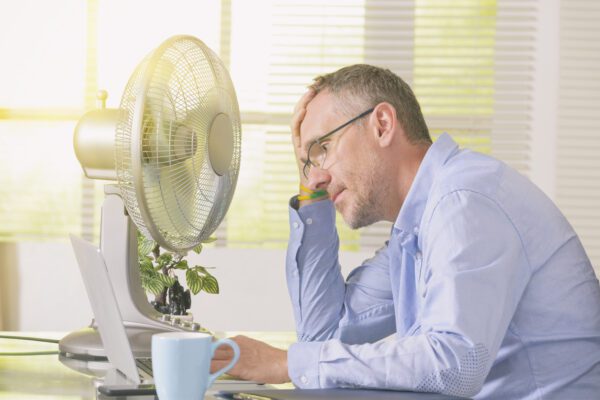 Overheated office worker waits for air conditioner rental installation
